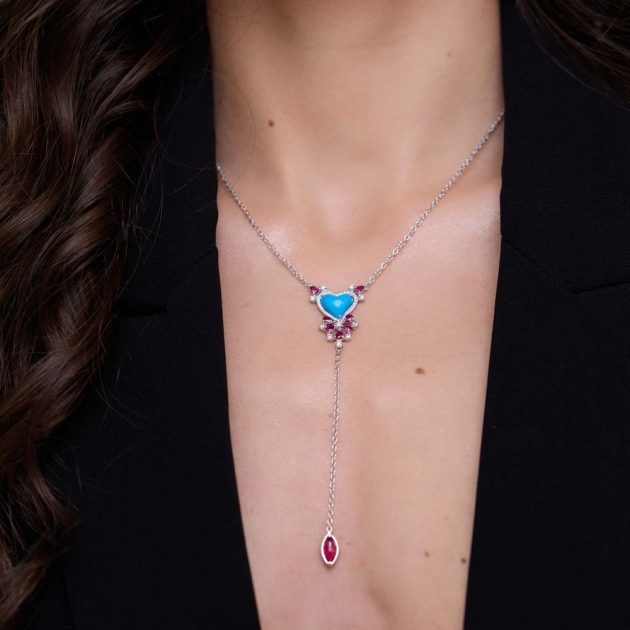 18-karat gold pendant with a turquoise heart, surrounded by round and marquise-cut rubies and diamond melee accents.