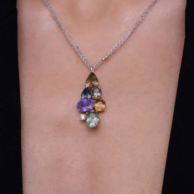 18-karat gold pendant with multicolored oval and pear-shaped sapphires, accented by a brilliant-cut diamond.